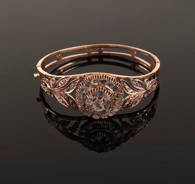 gros plan d'une bague en or et diamants sur une surface noire