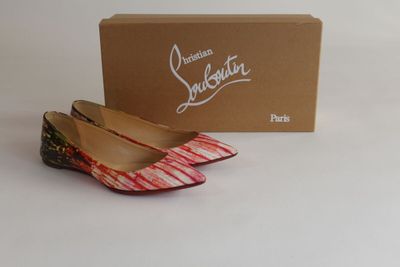 Chaussures Louis Vuitton dans leur boîte, posée sur une surface blanche