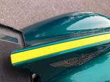 a close up of a green motorcycle with a yellow stripe on it