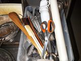 un bac rempli d'ustensiles de cuisine et d'autres articles de cuisine