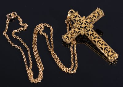 a close up of a cross on a chain on a black surface
