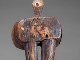 an image of a wooden sculpture of a man on a gray background