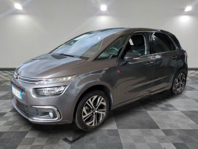 Une Citroën grise est garée dans une pièce au sol carrelé