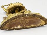 a gold plated object on a white surface