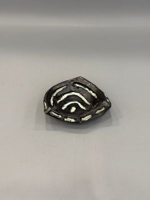 une image représentant une broche en noir et blanc posée sur une surface blanche