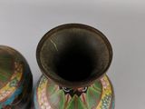two small vases sitting next to each other on a white surface