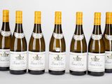 six bouteilles de vin sont alignées sur une table