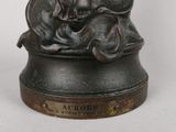 a bronze statue of a man and a dog on a table