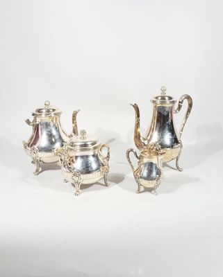 two silver teapots and a coffee pot on a stand