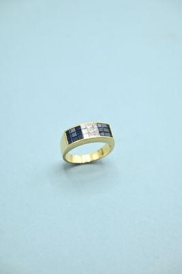 a close up of a gold ring with blue and white diamonds