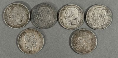 six types différents de pièces d'argent sur une surface grise