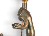a statue of a mermaid holding a candle on a wall