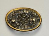 a silver and gold plate with a bird and flowers on it