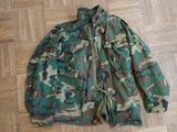 camouflage jacket sitting on a wooden floor on a hard wood floor