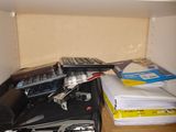 scissors, binders, and other office supplies sit on a shelf