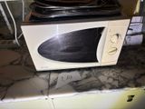 a microwave sitting on top of a counter with a price tag on it