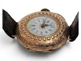 a gold watch with a white face on a black strap