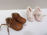 deux paires de chaussures de bébé posées l'une à côté de l'autre sur une table