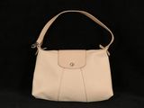 un sac à main blanc posé sur une surface noire