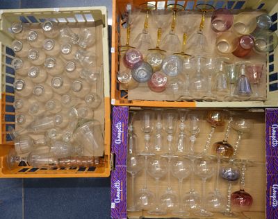 des cartons contenant des verres à vin vides, posés sur un sol carrelé