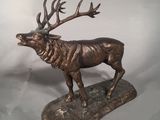 statue d'un cerf posé sur un rocher, sur lequel sont posés ses bois
