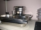 many pans and containers sitting on a kitchen counter