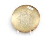 a gold plate with a design on it on a stand