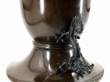 a black vase with a dragon on it on a white background