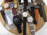 a lot of watches that are sitting on a wooden plate