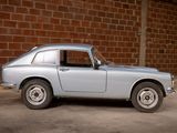 a silver car that is parked in front of a brick wall