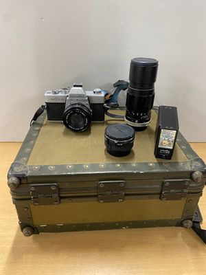 un appareil photo, un étui pour appareil photo et un téléphone portable posés sur une table