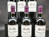 six bouteilles de vin sont alignées sur une table