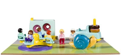 un petit train miniature avec des figurines à bord, posé sur une table