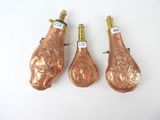 three antique copper wine bottles with a floral design on them