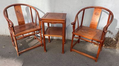 trois chaises en bois et une table devant un mur blanc