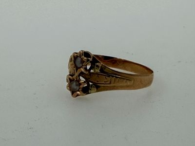 an image of a gold ring with black stones