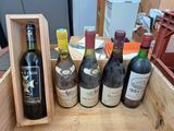 plusieurs bouteilles de vin se trouvent dans un coffret en bois sur une table