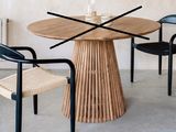 deux chaises et une table dans une pièce où est accrochée une horloge au mur