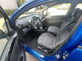 the interior of a small blue car with the door open