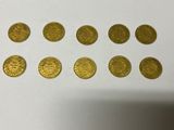 a bunch of gold coins sitting on top of a white table
