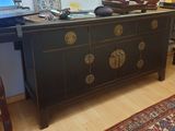 un ordinateur portable posé sur une commode dans un salon