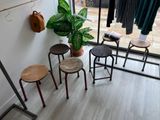 three stools in front of a window with clothes hanging on it