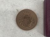 a small coin sitting next to a small purple wallet
