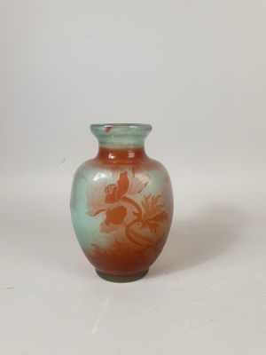 un petit vase posé sur une surface blanche