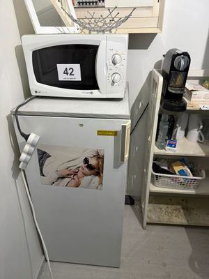 un réfrigérateur surmonté d'un micro-ondes dans une cuisine