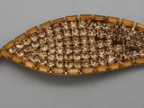 une broche de couleur dorée ornée d'un motif tressé