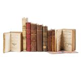 several old books are stacked on top of each other on a white surface