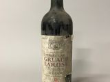 une vieille bouteille de vin posée sur une table blanche