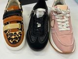 three pairs of children ' s shoes sitting on a table