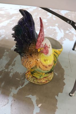 une figurine représentant un poulet posée sur une table, à côté d'une paire de ciseaux